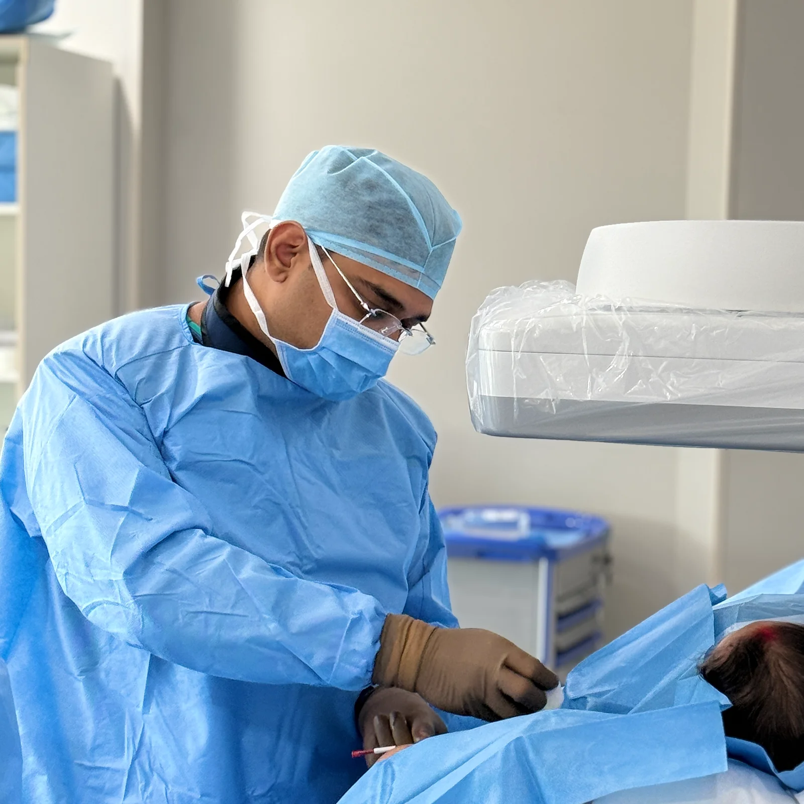 homepage 16 Surgeon performing a medical procedure, dressed in surgical gear.