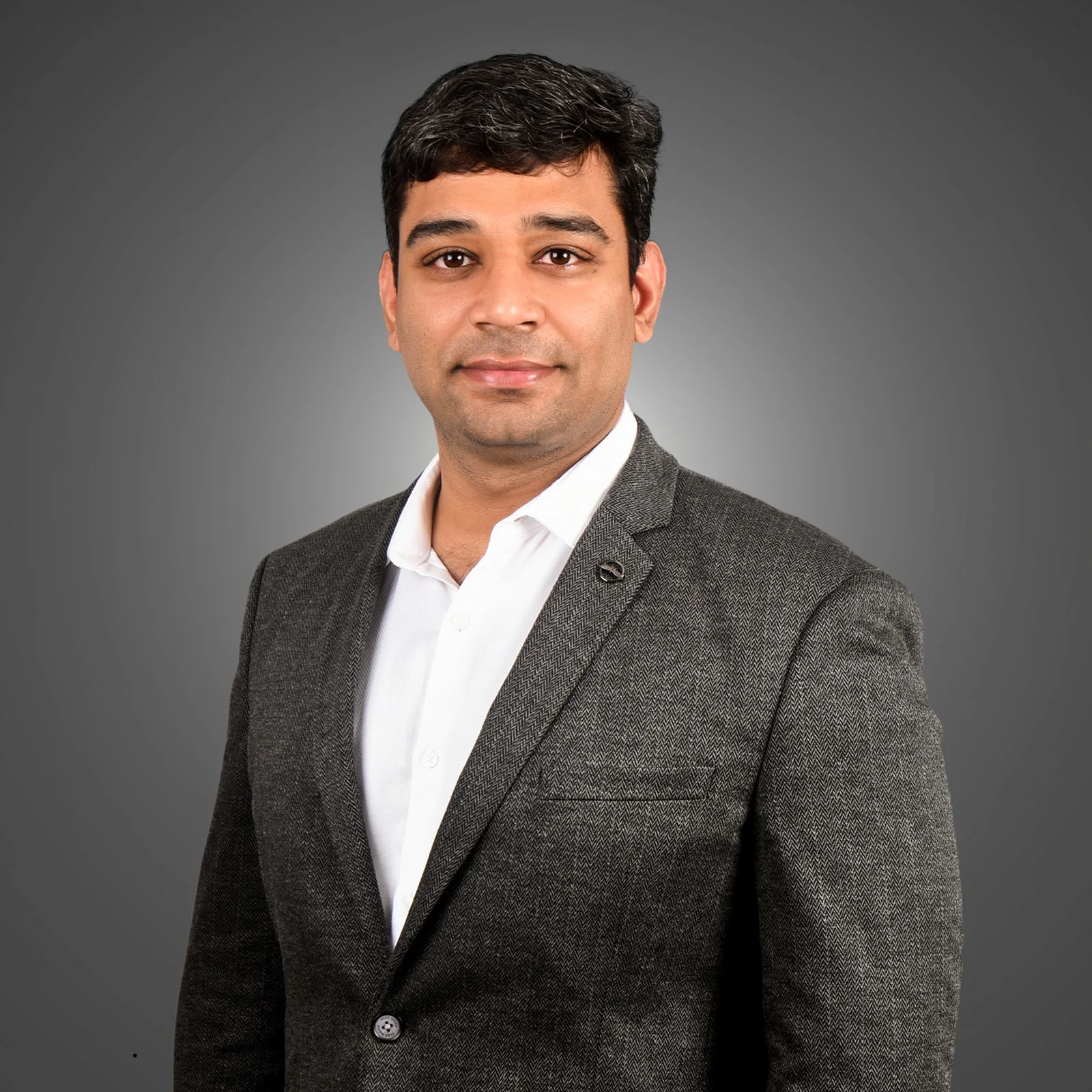 homepage 14 Dr. Monish V. in a suit and shirt, posing with a confident expression.